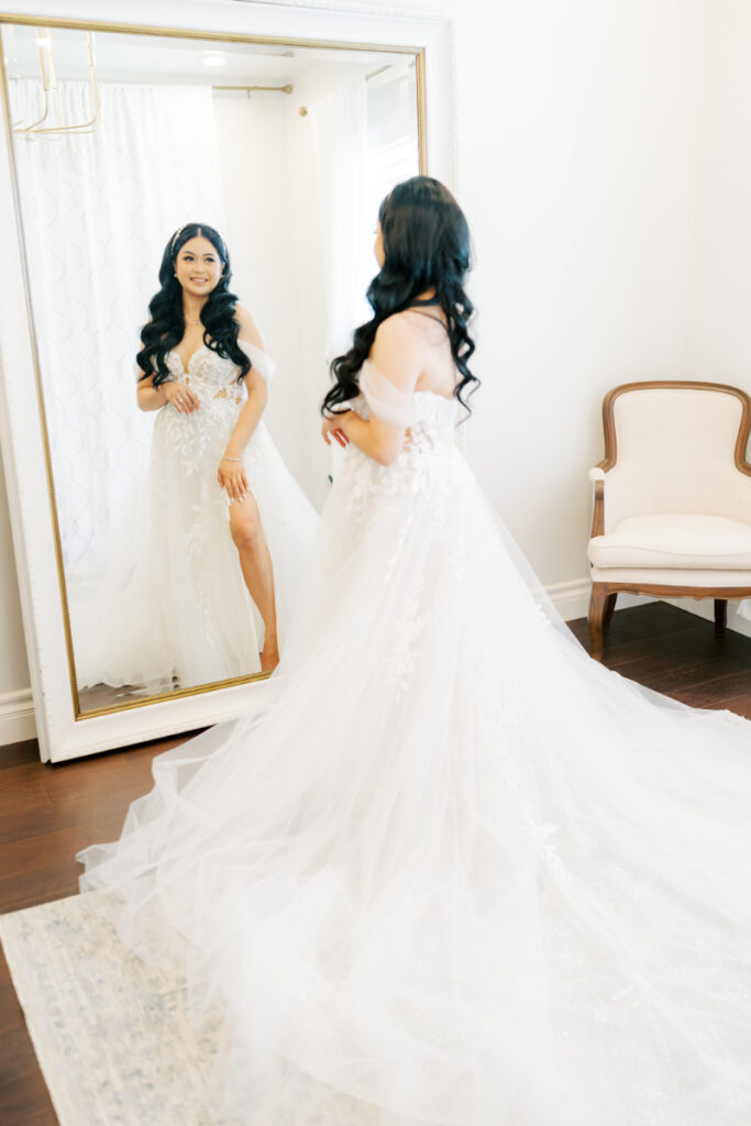 Bride looks at her San Francisco bridal shop dress in the mirror of the bridal suite