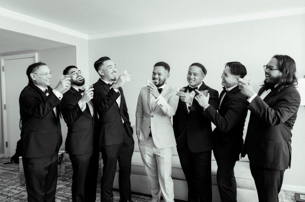 groomsmen and groom sip champagne after getting ready for the San Jose wedding 