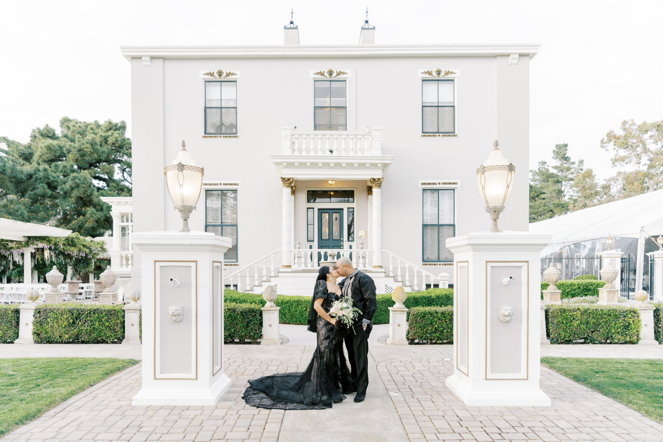 San Francisco bride in black dress and her groom stand in front of Jefferson Street Mansion wedding venue in San Francisco